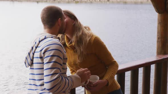 Caucasian couple spending time at home together, kissing outside the cabin