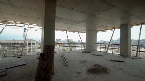 Camera moves through construction site high building with view of city