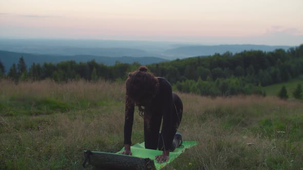 Active Charming Sporty Fit Black Woman Exercising Yoga Cat Pose on Mountain Hill at Daybreak