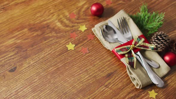 Video of christmas decorations with cutlery and copy space on wooden background