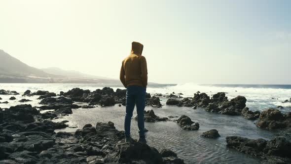 Tourist Man in Yellow Sweatshirt Walks on Volcanic Beach in North of Canary Island Tenerife