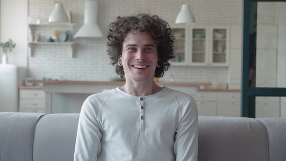 A Shocked Hipster Man in White Sweater and Shirt Saying Wow and Covering Her Mouth While Standing in