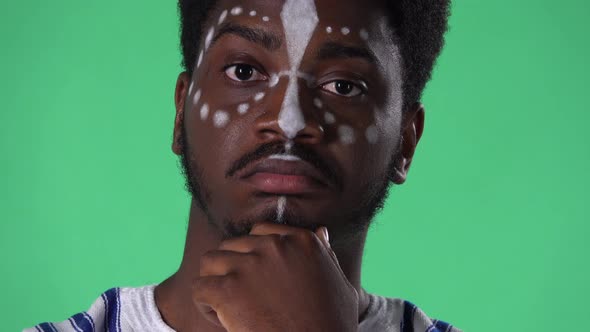 Portrait of Young African American Man Listens to Information Looking at Camera