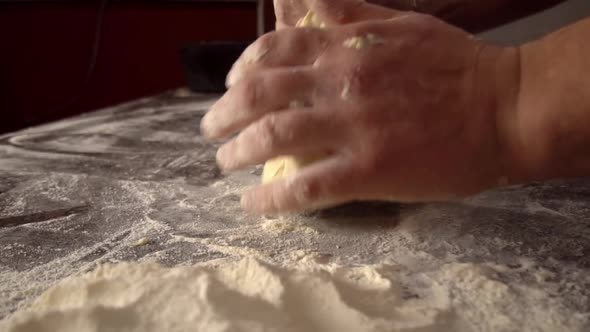 Men's hands hold dough. making raw dough for pizza, rolls or bread.