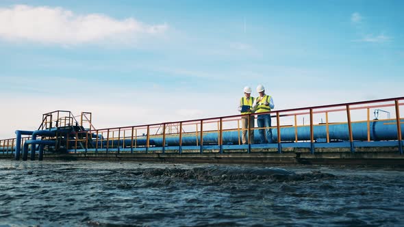 Wastewater Treatment Site with Engineers Analyzing Probes