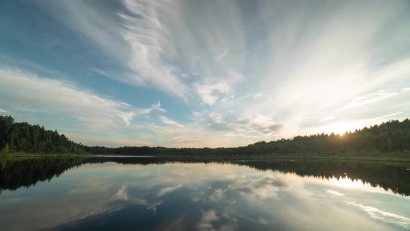 hyperlapse of the reflection of floating clouds in the lake at sunset