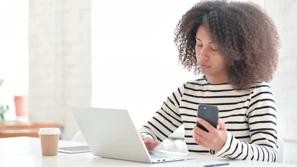 Young African Female Designer Working on Laptop and Smartphone