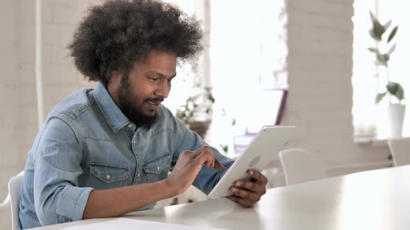 African Man Celebrating Success While Using Tablet