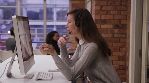 Creative businesswoman wearing headset talking in modern office