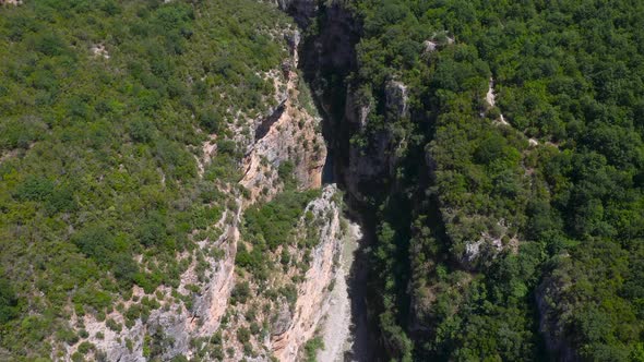 Birds eye view of deep gorge between steep and huge green mountains of Benje Canyon. Aerial view.