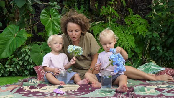 A Family Day Outdoors Single Mom with Her Twin Daughters Enjoying the Beauty of Hydrangea Flowers on