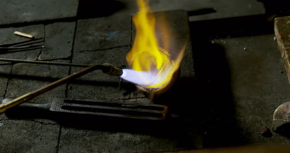 Welding torch is being used to melt jewellery in workshop 4k