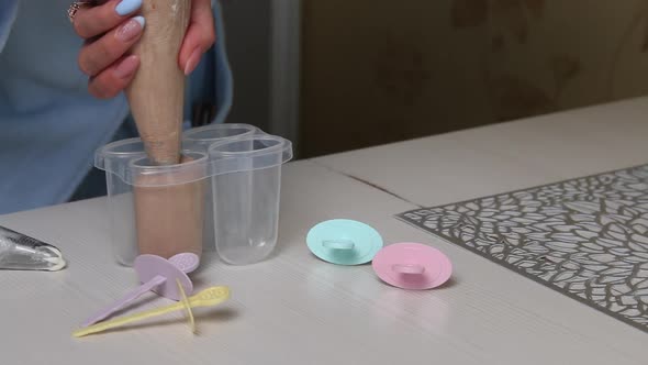 A Woman Fills An Ice Cream Lolly Mold With Buttercream.