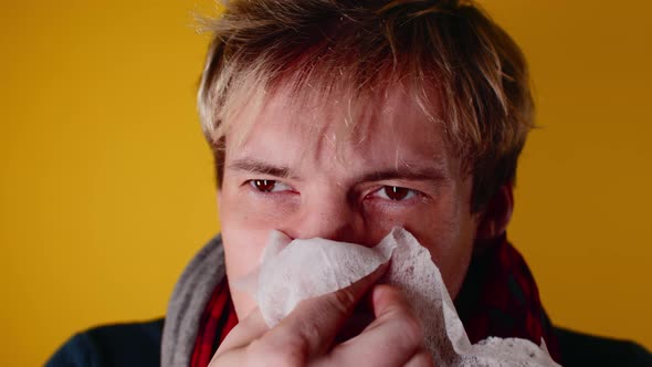 The man has a runny nose. A young guy in a scarf wipes his snot.