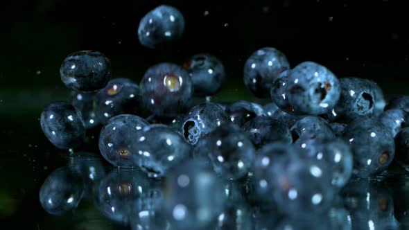 Super Slow Motion Shot of Fresh Blueberries Falling Into Water and Splashing at 1000Fps.