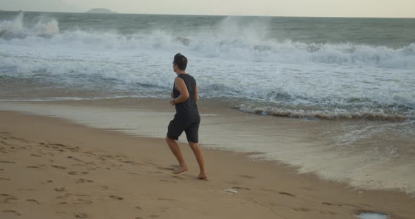 Young Caucasian Man Are Exercising with Outdoor Running with a Beautiful Sea Background