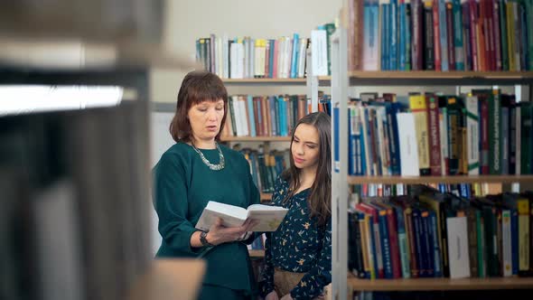 Female University Student Working In Library With Tutor