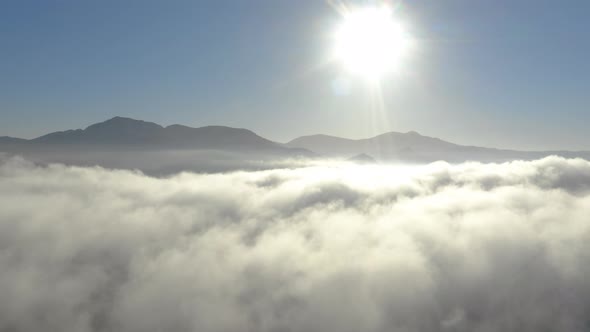 Aerial view of low fog over mountains in San Diego during sunrise