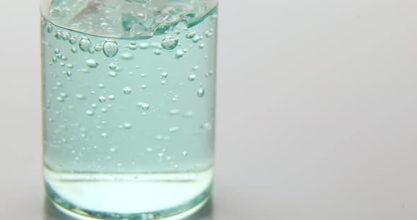 Close up of blue serum poured in a medical glass bottle