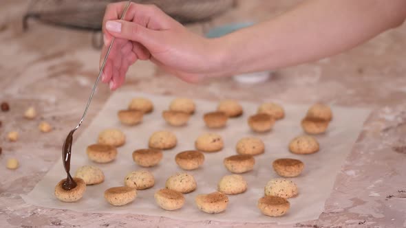 Woman Holding Spoon of Melted Dark Chocolate in Baking Cookies