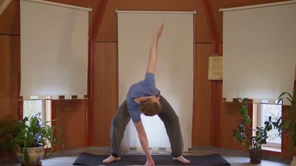 Sporty Guy Doing Upright Exercise to Stretch Shoulder and Neck Muscle at Home