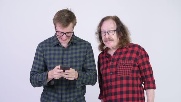 Senior Hipster Man Getting Angry at Young Hipster Man Using Phone