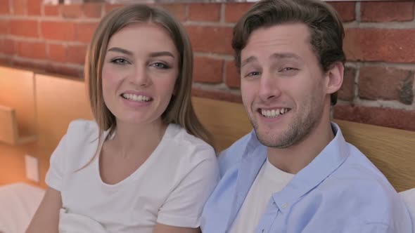 Portrait of Young Couple Doing Video Chat in Bed