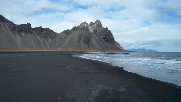 Iceland Drone over black sand beach with waves crashing on shore
