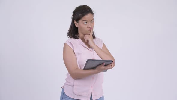 Young Happy Asian Businesswoman Thinking While Using Digital Tablet