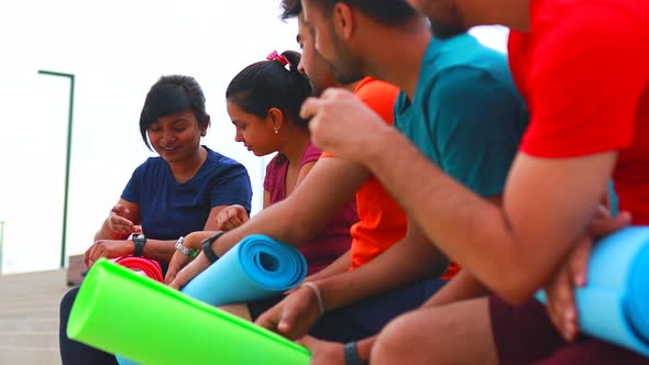 Eastern Ethnic People Exercising Together Outdoor Talking