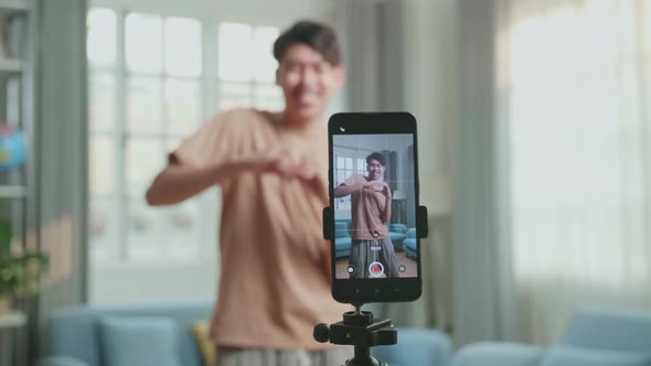 Display Smartphone Of Asian Man Dancing While Shooting Video Content For Social Networks