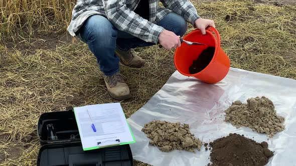 Agronomist Pouring Soil Sample From Bucket on Plastic Underlay Outdoor