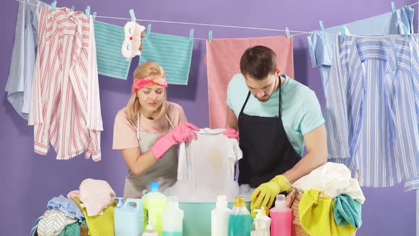 Couple Advertising Washing Powder. Isolated Blue Background. Studio Shot