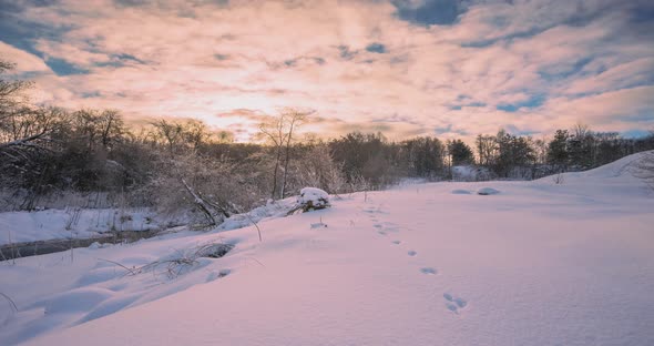 Winter Sunset Timelapse with Snow and River Stream in the Background