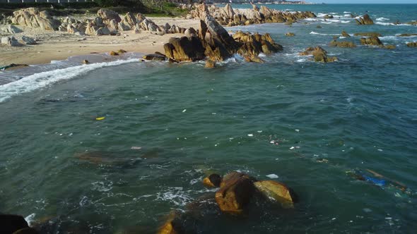 Littered Garbage Floating In The Ocean Off The Shore Of A Rubbish Beach In Vietnam. drone shot, low