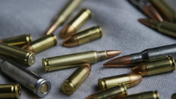 Cinematic rotating shot of bullets on a fabric surface - BULLETS 095