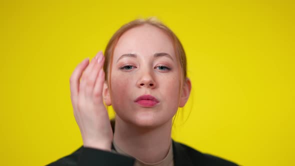 Closeup of Charming Caucasian Redhead Woman Looking at Camera Sending Air Kiss