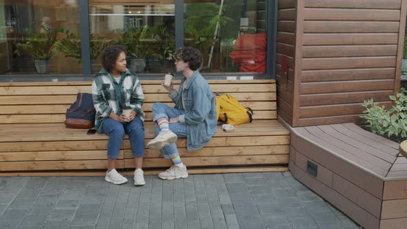 Young Friends Chatting on Bench