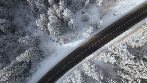 Aerial View of Winter Landscape with Snow Covered Mountain Woods and Winding Forest Slippery Road