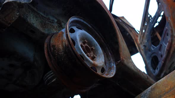 Closeup Burnt Down Car Wheel with No Tire Outdoors at Automobile Dump