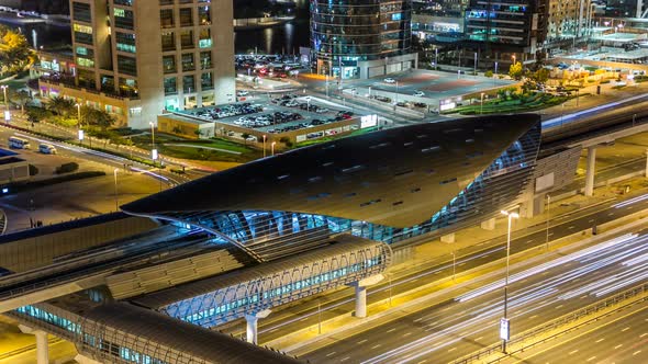 Metro Station Near Buildings of Jumeirah Lakes Towers with Traffic on the Road Night Timelapse