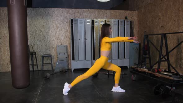 a Beautiful Girl in a Yellow Tracksuit Does Stretching