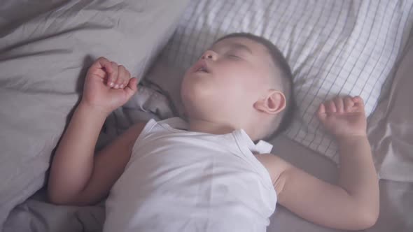 Relaxing video clip of a lovely two years old Asian toddler comfortably and deeply sleeping or takin