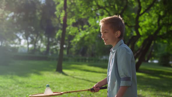 Smiling Joyful Boy Put Shuttlecock on Racket