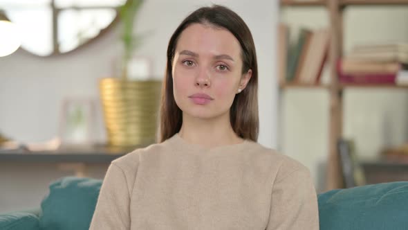 Portrait of Young Woman Looking at Camera at Home 