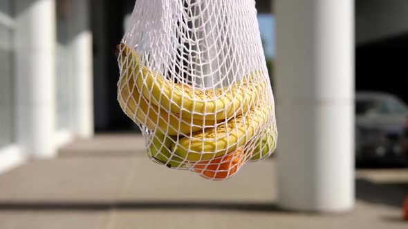 Eco bag with fruits spinning round on a street background