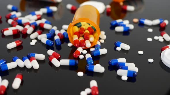 Many prescription pills, drugs and antidepressants falling in slow motion on an orange pharmacy medi