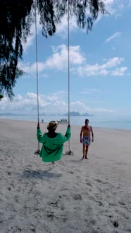 Phuket Thailand Naka Island Couple Men and Woman at a Swing on the Beach