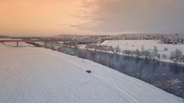 Drone shooting of a river against the background of a forest and a bridge