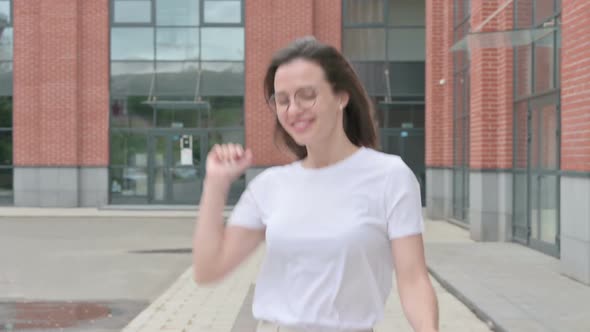 Young Woman Dancing in Joy while Walking on Street
